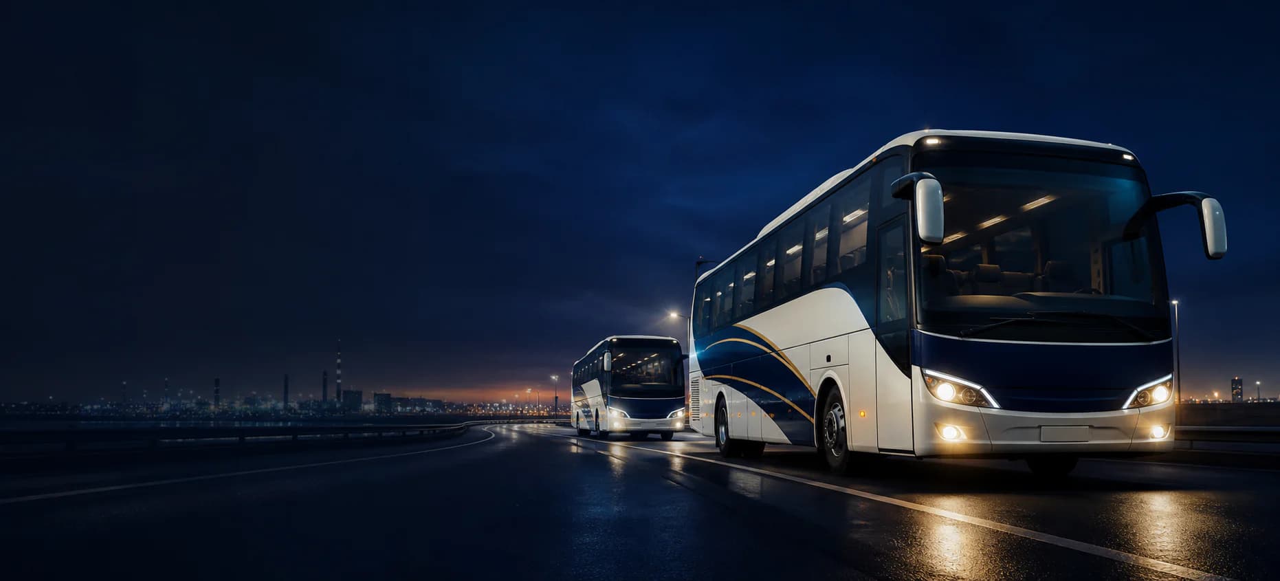 Two premium employee transport coaches travelling on a highway at blue hour